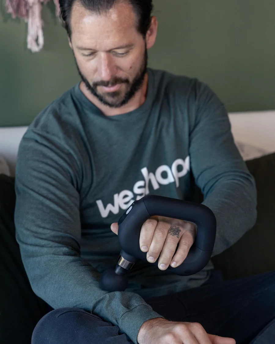 Coach Tyler using the WeRevive massage device on his forearm