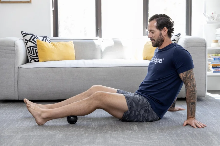 Coach Tyler rolling his calf on the WeRelease massage ball